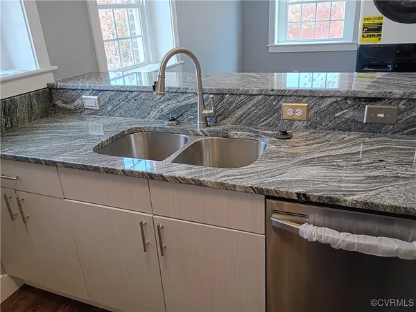 a kitchen with granite countertop a sink and a stove