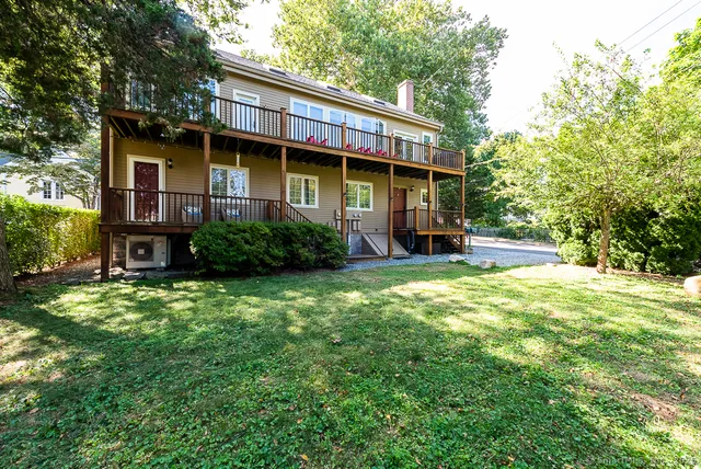 a view of a house with a yard and lawn chairs