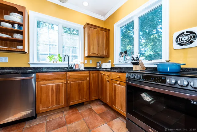 a kitchen with stainless steel appliances granite countertop a sink a stove and a microwave