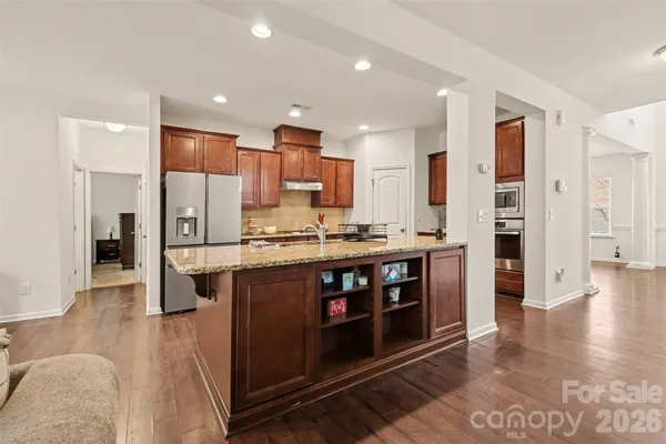 a kitchen with stainless steel appliances granite countertop a stove a refrigerator and a wooden cabinets