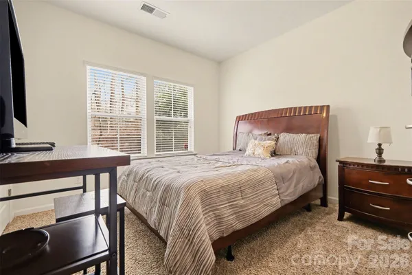 a bedroom with a bed and a flat tv screen on dresser