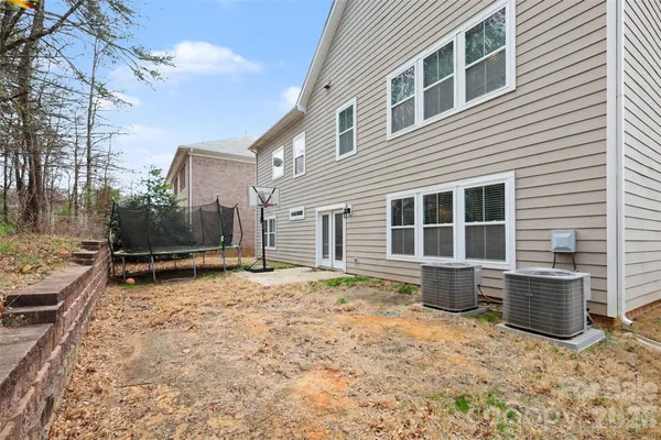 a backyard of a house with barbeque oven and potted plants
