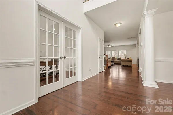 a view of an empty room with kitchen and dining room