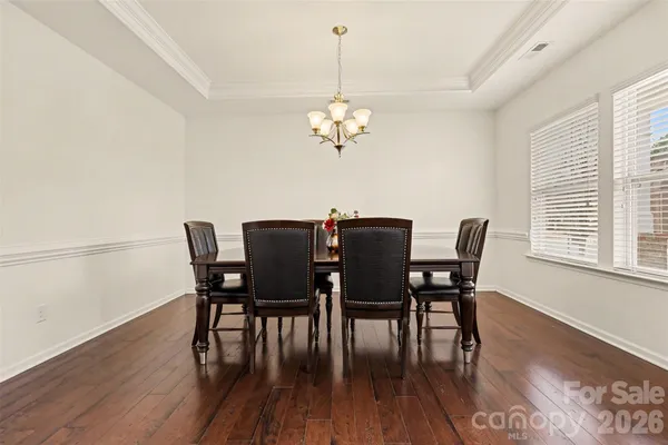 a view of a dining room with furniture a chandelier and wooden floor