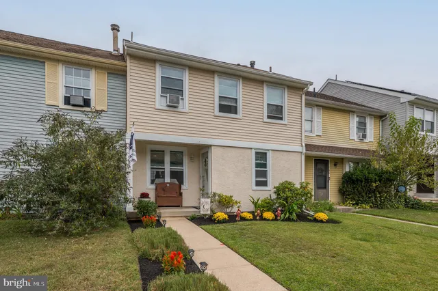 a front view of a house with a garden and plants