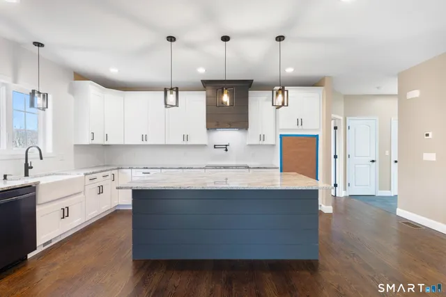 a kitchen with kitchen island a sink a center island stainless steel appliances and cabinets