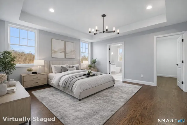 a spacious bedroom with a bed and a chandelier