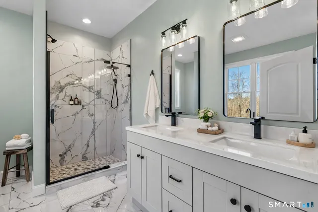 a bathroom with a double vanity sink mirror and shower