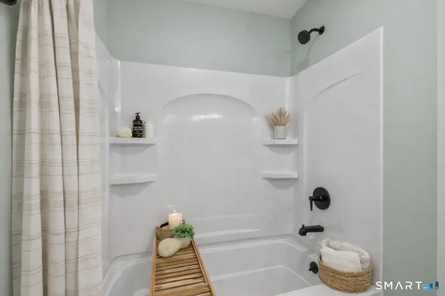 a bathroom with a bathtub a toilet and a shower