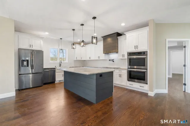 a large kitchen with stainless steel appliances and a refrigerator