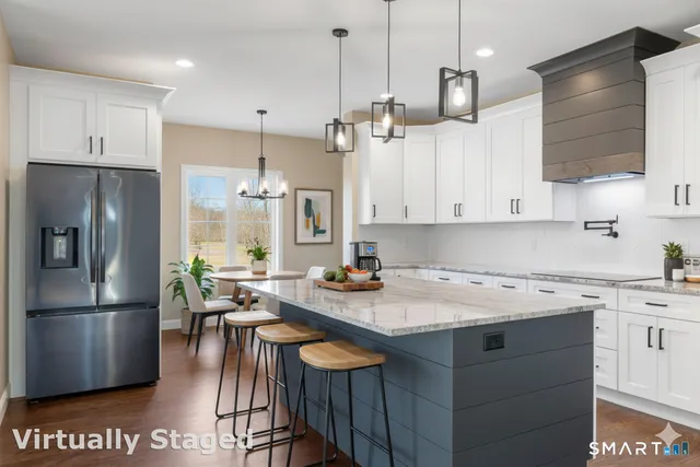 a kitchen with stainless steel appliances granite countertop a sink a stove a refrigerator and island with wooden floor