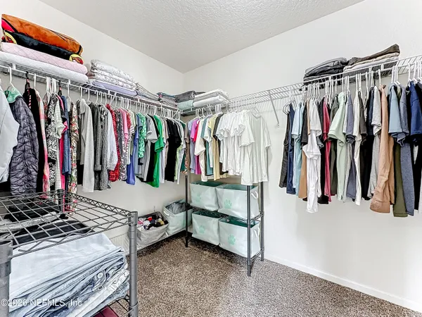 a view of walk in closet with clothes