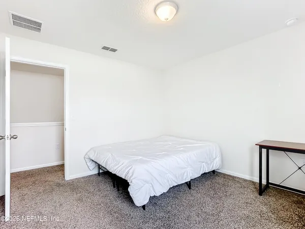 a bed sitting in a room next to a cabinet