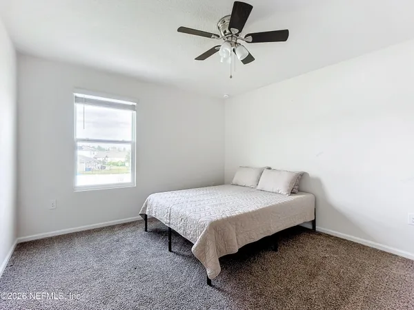 a bed sitting in a bedroom next to a window