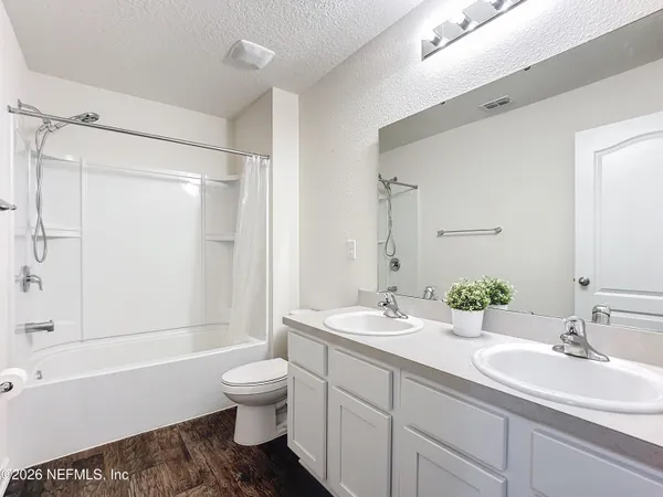 a bathroom with a double vanity sink toilet mirror and shower