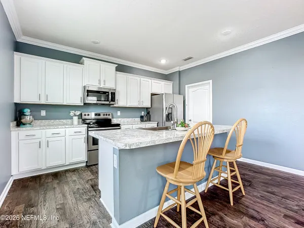 a kitchen with stainless steel appliances granite countertop a white cabinets and a stove top oven