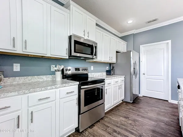 a kitchen with stainless steel appliances granite countertop a sink a stove a microwave and cabinets