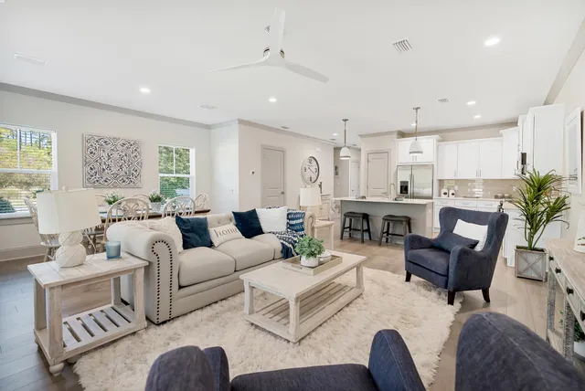 a living room with furniture kitchen view and a potted plant