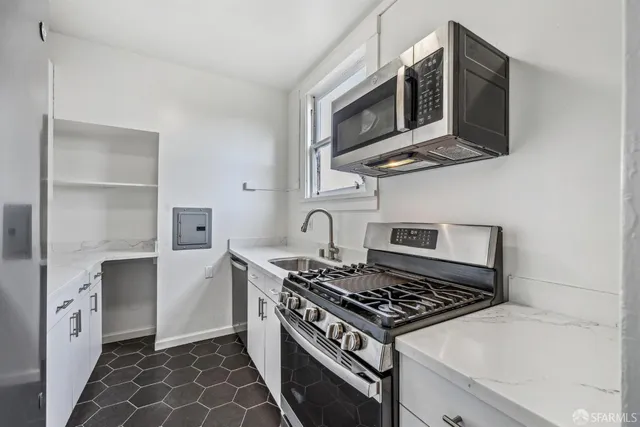 a kitchen with stainless steel appliances granite countertop a stove and a microwave
