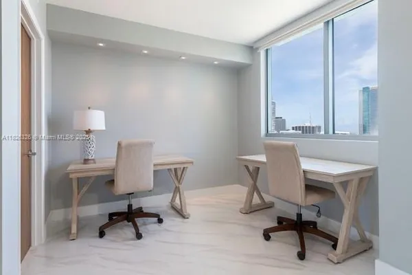 a view of a workspace with furniture and a window