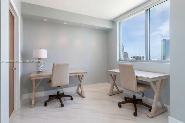 a view of a workspace with furniture and a window