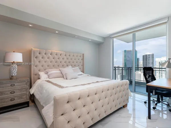 a bedroom with a bed a table and painting