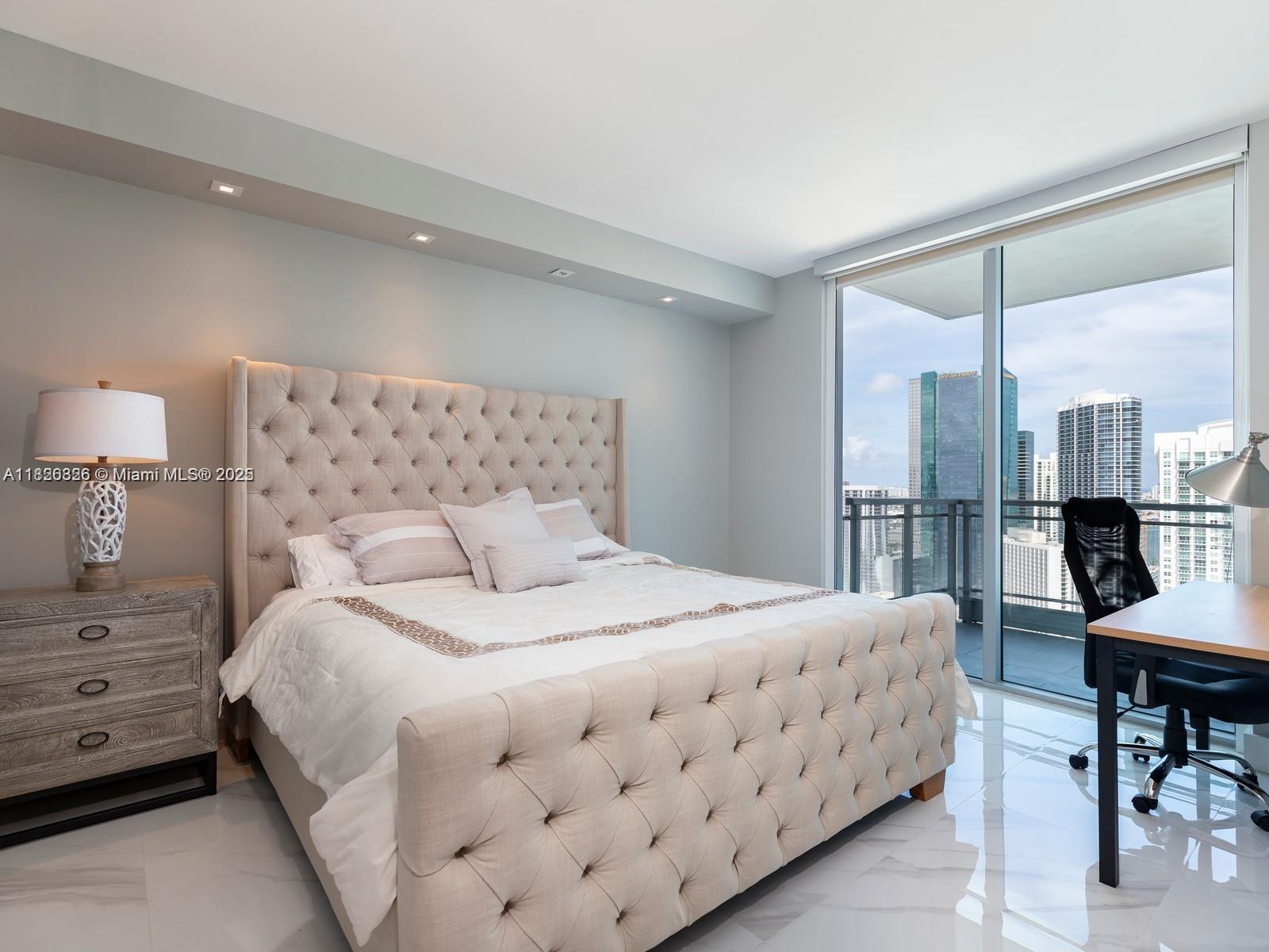 92 Southwest 3rd Street, Unit 3901 Miami, FL 33130 - Photo 8 of 10 a bedroom with a bed a table and painting