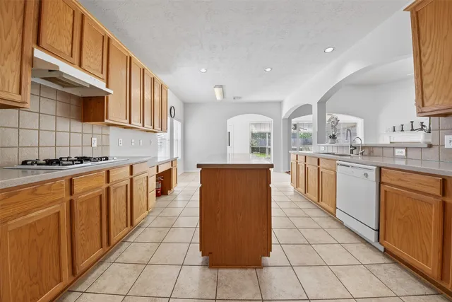 a large kitchen with stainless steel appliances kitchen island granite countertop a large counter top and a stove