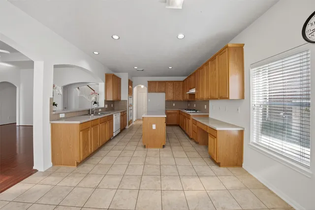 a large kitchen with stainless steel appliances lots of counter space and windows