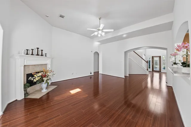a view of an empty room with window and wooden floor