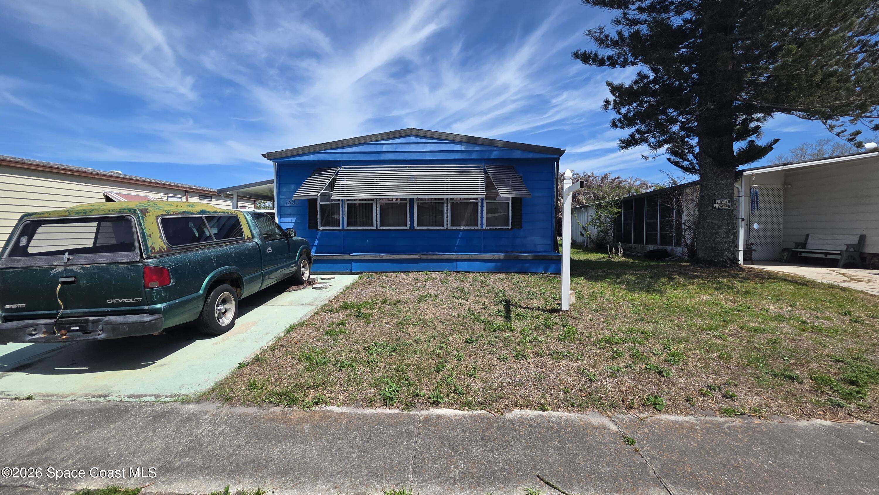 1805 Mango Street Northeast Palm Bay, FL 32905 - Photo 1 of 22 a front view of a house with a yard