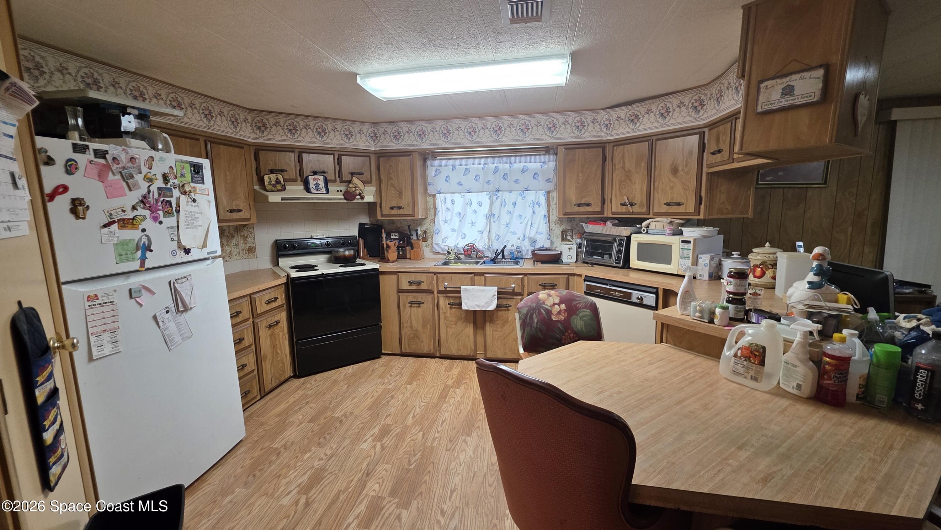 1805 Mango Street Northeast Palm Bay, FL 32905 - Photo 9 of 22 a kitchen with stainless steel appliances granite countertop a sink dishwasher stove refrigerator and cabinets