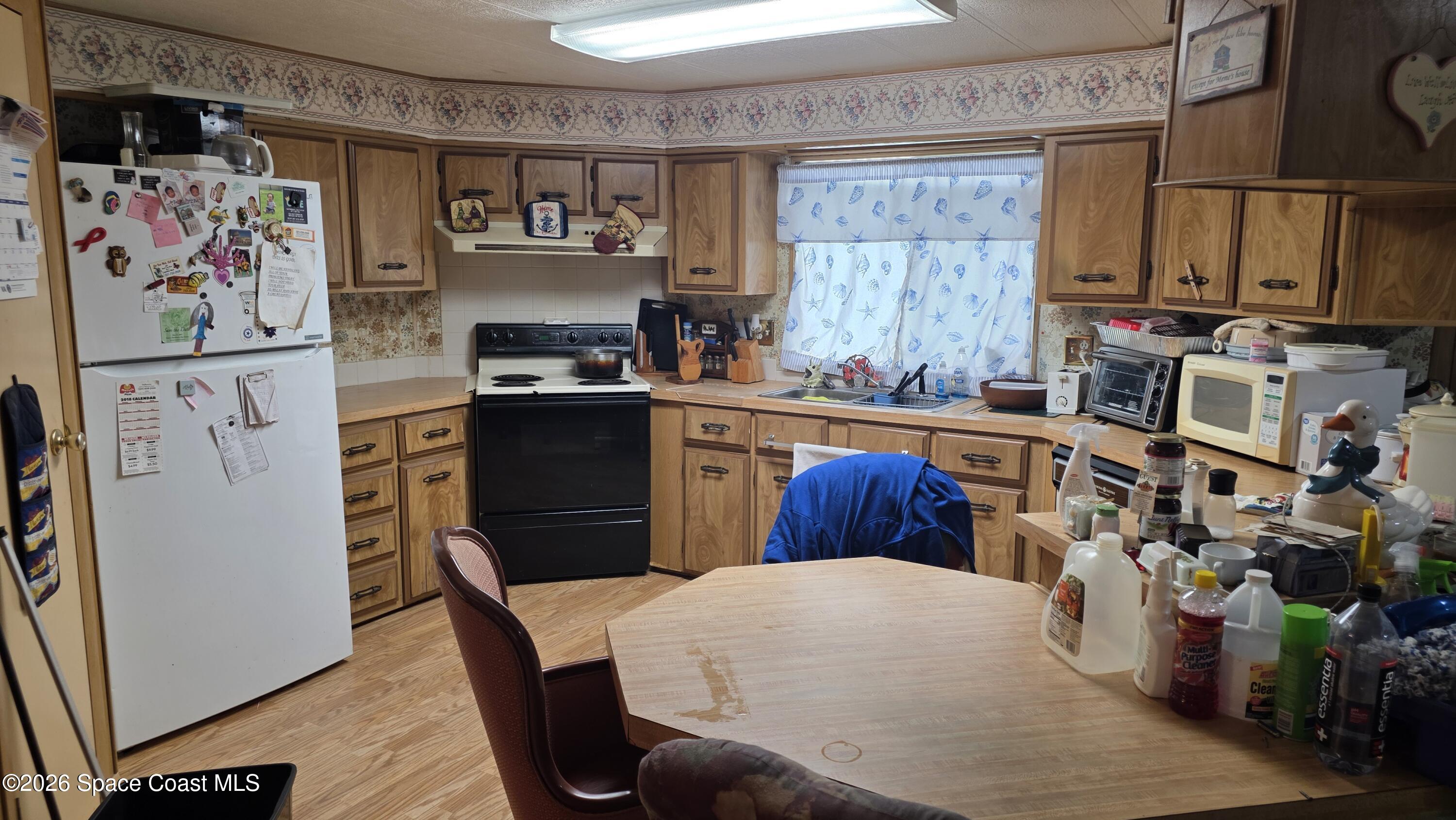1805 Mango Street Northeast Palm Bay, FL 32905 - Photo 10 of 22 a kitchen with stainless steel appliances granite countertop a refrigerator and a stove top oven