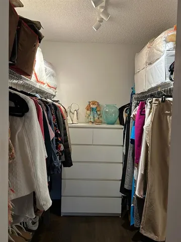 a view of walk in closet with clothes and shoes