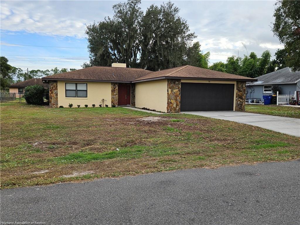 511 Elgin Street Sebring, FL 33875 - Photo 1 of 30 a front view of a house with a yard and garage
