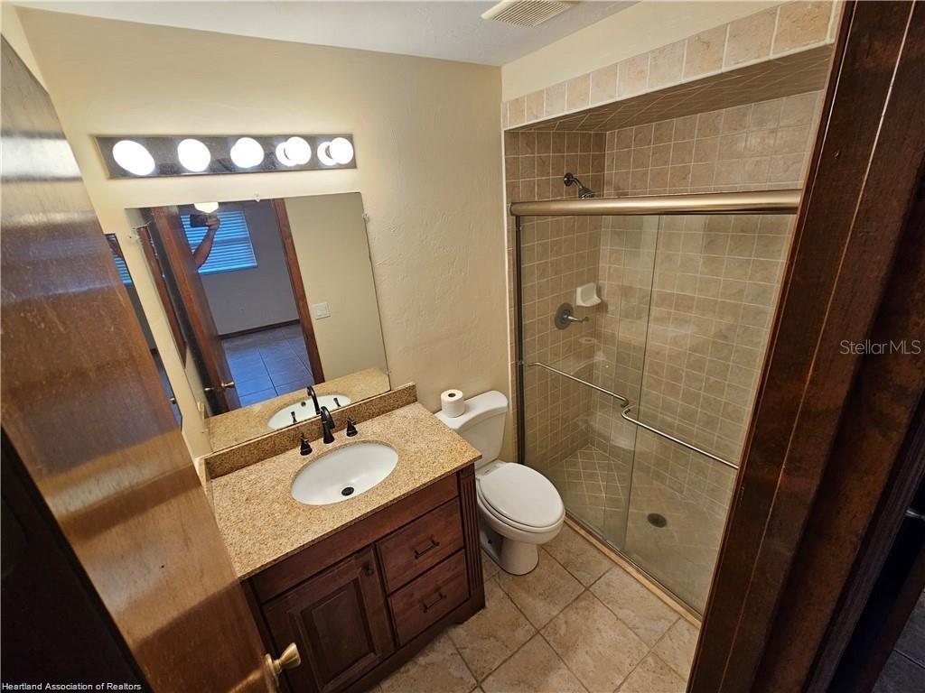 511 Elgin Street Sebring, FL 33875 - Photo 14 of 30 a bathroom with a sink a toilet a mirror and shower