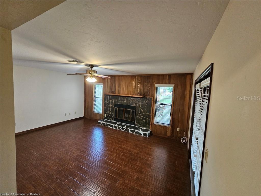 511 Elgin Street Sebring, FL 33875 - Photo 23 of 30 a view of an empty room with wooden floor fireplace and a window