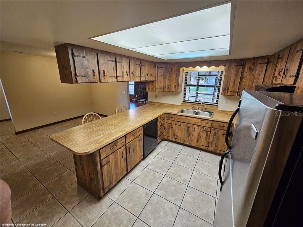 511 Elgin Street Sebring, FL 33875 - Photo 24 of 30 a kitchen with stainless steel appliances granite countertop a sink counter space cabinets and a window
