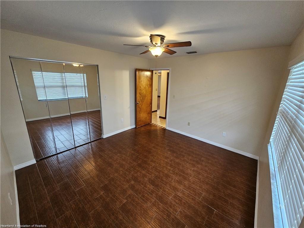 511 Elgin Street Sebring, FL 33875 - Photo 26 of 30 wooden floor in an empty room with a window
