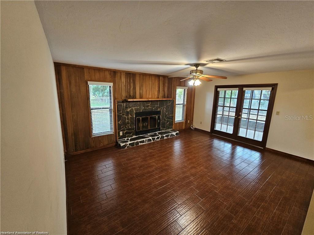 511 Elgin Street Sebring, FL 33875 - Photo 30 of 30 an empty room with wooden floor fireplace and windows