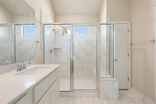 a bathroom with a shower sink and mirror