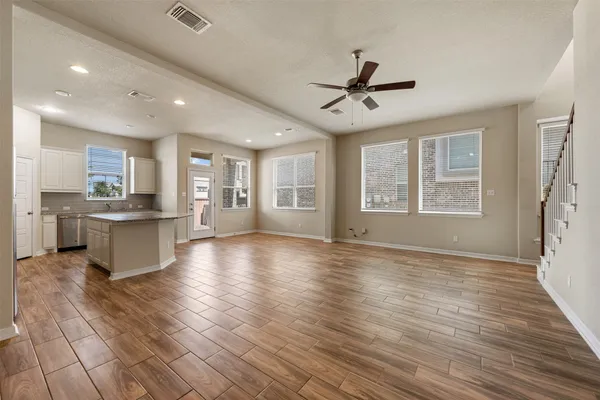 a view of an empty room with window and wooden floor