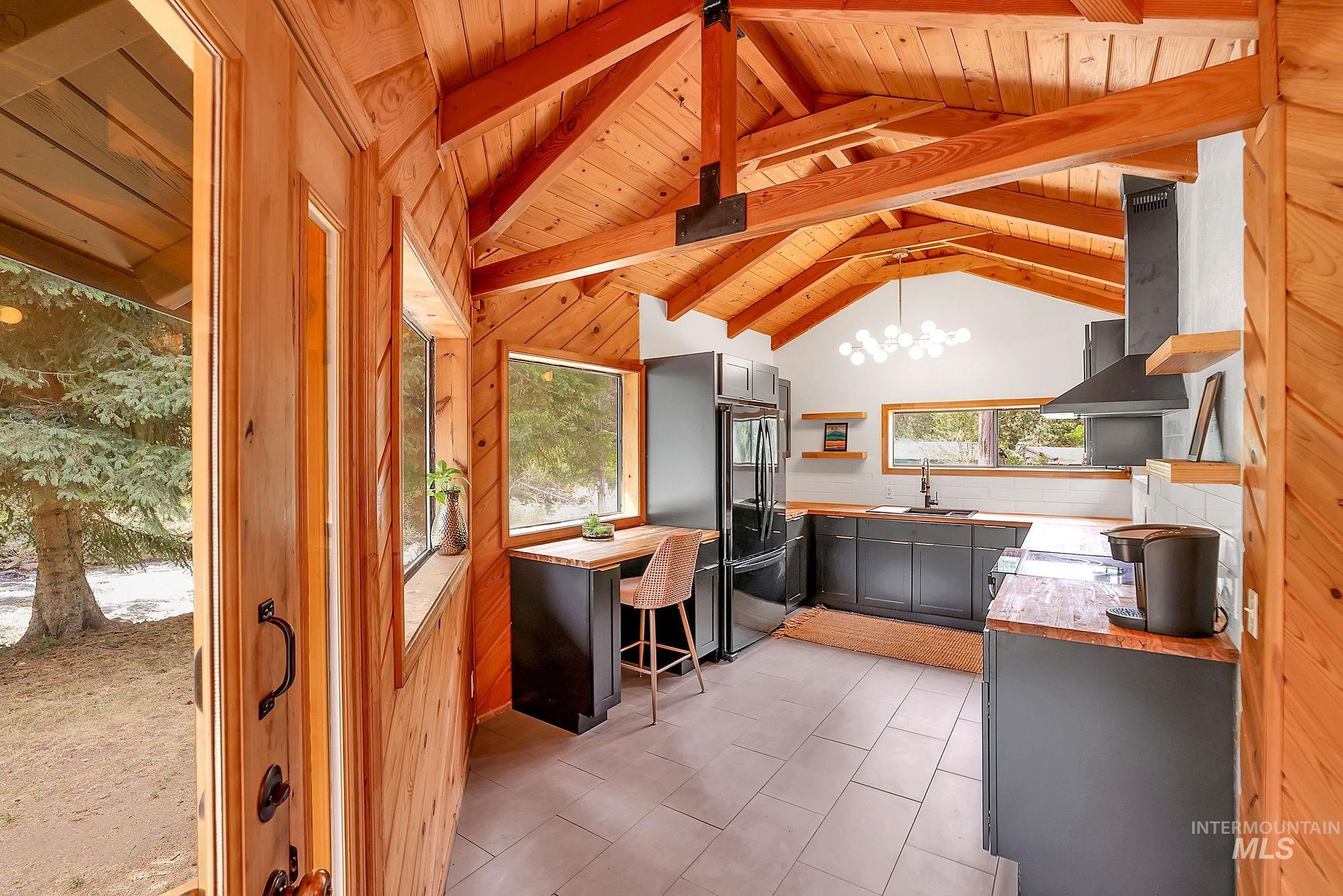 5713 Pines Road New Meadows, ID 83654 - Photo 13 of 45 Kitchen featuring extractor fan, open shelves, a high wood beamed ceiling, freestanding refrigerator, and hanging lights