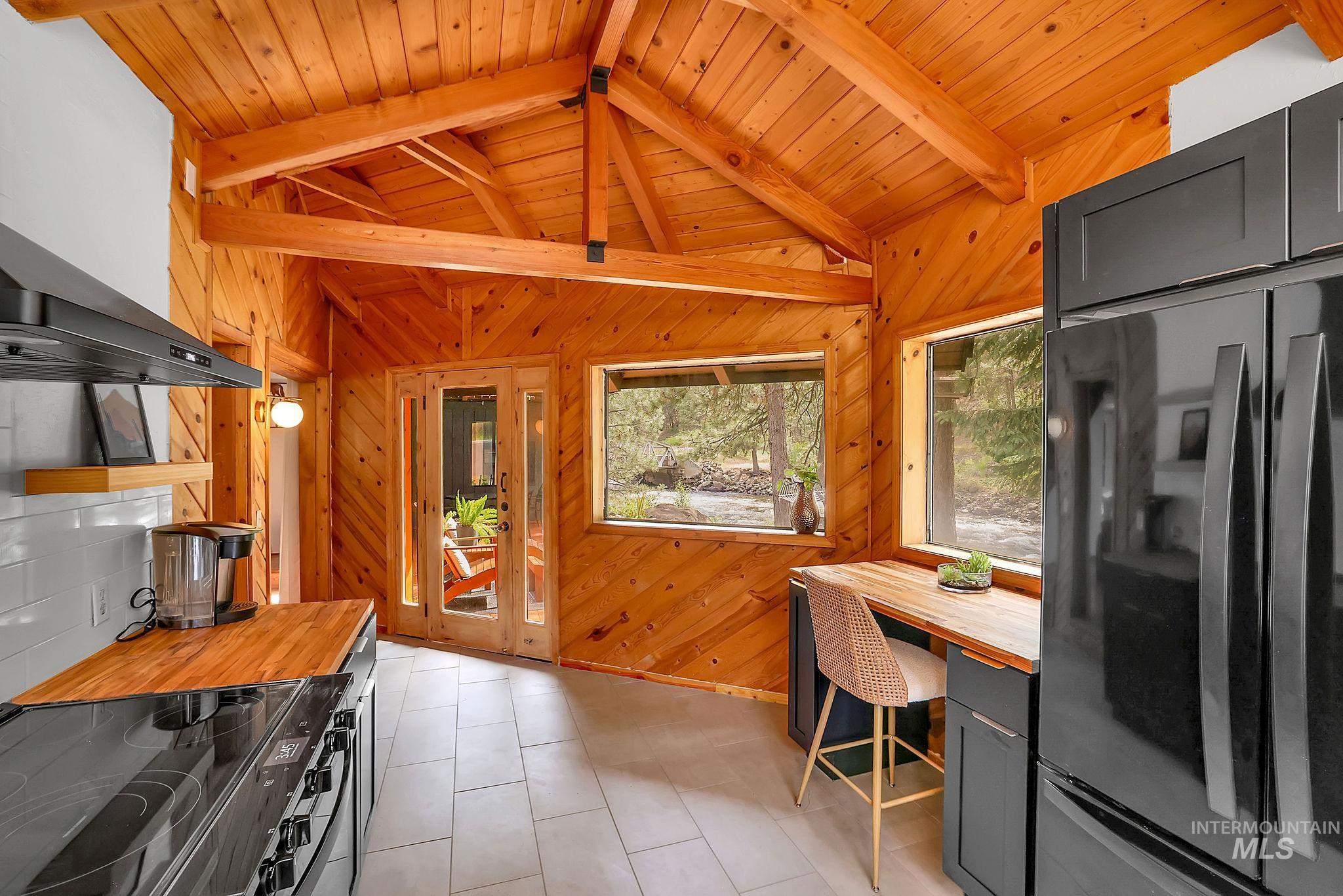 5713 Pines Road New Meadows, ID 83654 - Photo 14 of 45 Kitchen featuring freestanding refrigerator, black range with electric cooktop, butcher block counters, wooden ceiling, and lofted ceiling with beams