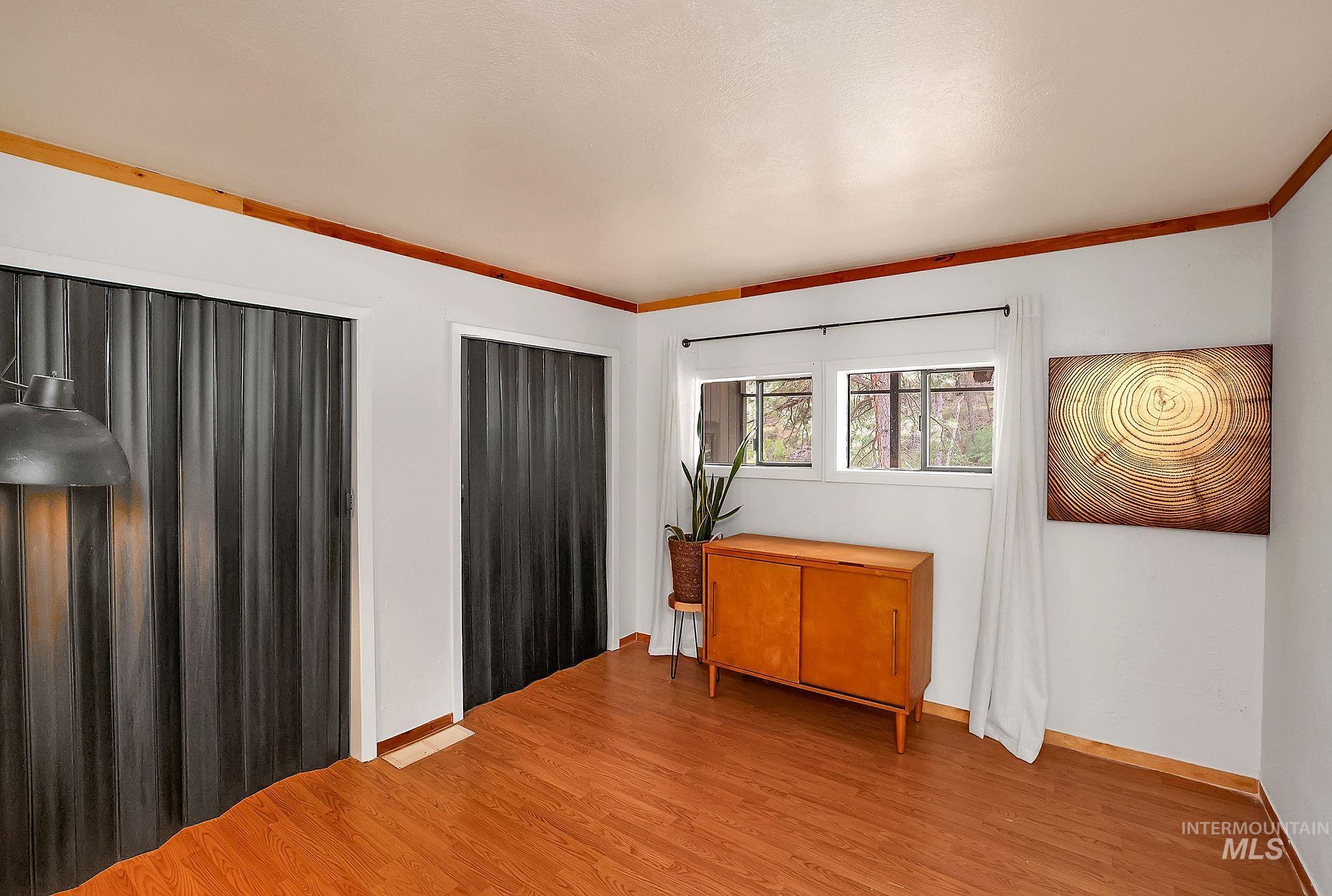 5713 Pines Road New Meadows, ID 83654 - Photo 24 of 45 Unfurnished bedroom featuring two closets, light wood-style flooring, and ornamental molding