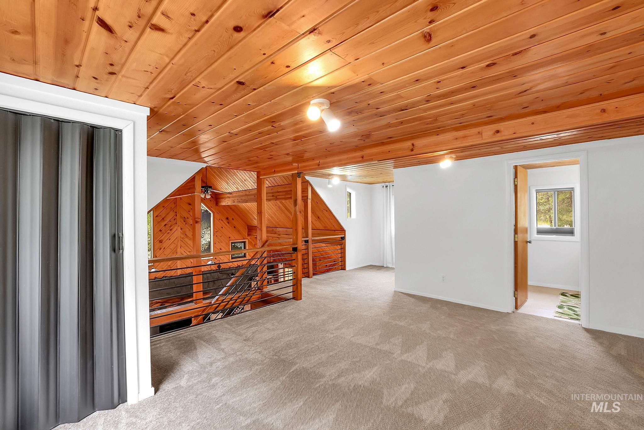 5713 Pines Road New Meadows, ID 83654 - Photo 28 of 45 Additional living space featuring wooden ceiling, carpet flooring, and wooden walls