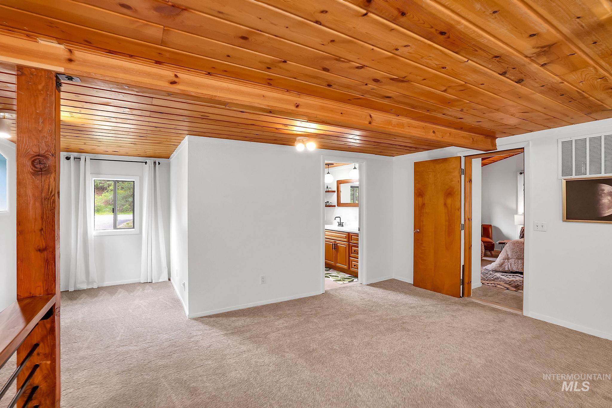 5713 Pines Road New Meadows, ID 83654 - Photo 29 of 45 Unfurnished living room with wood ceiling, light colored carpet, and wet bar