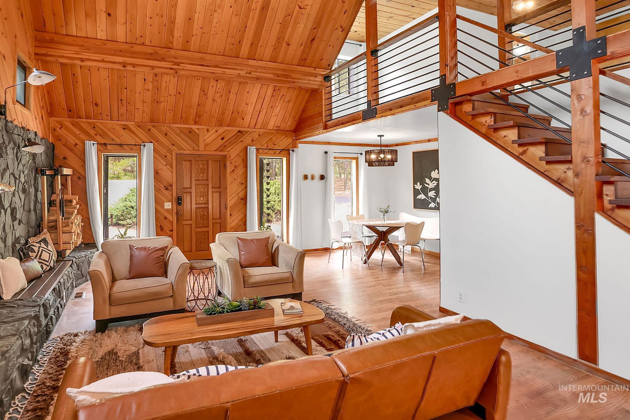 5713 Pines Road New Meadows, ID 83654 - Photo 9 of 45 Living area with wood finished floors, wooden walls, a chandelier, and a high wood beamed ceiling