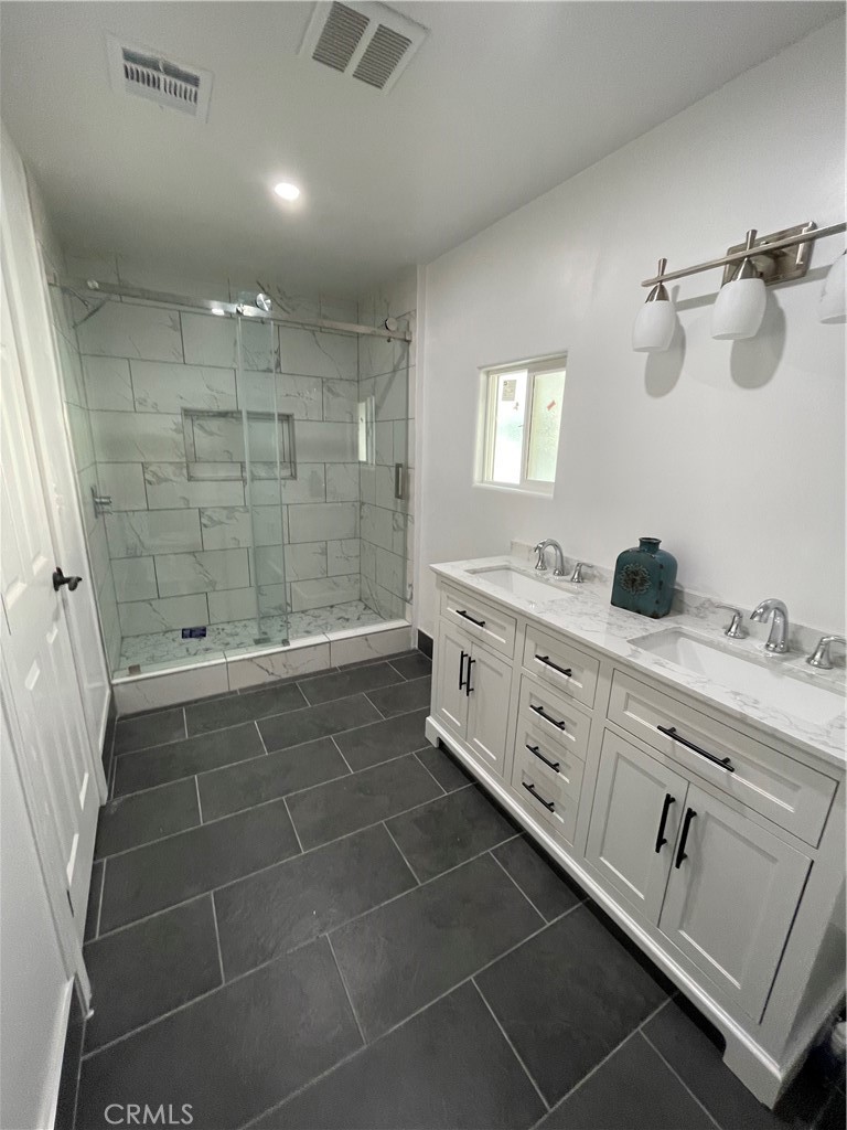 3745 Valley Boulevard Walnut, CA 91789 - Photo 6 of 10 a bathroom with a double vanity sink a mirror and shower
