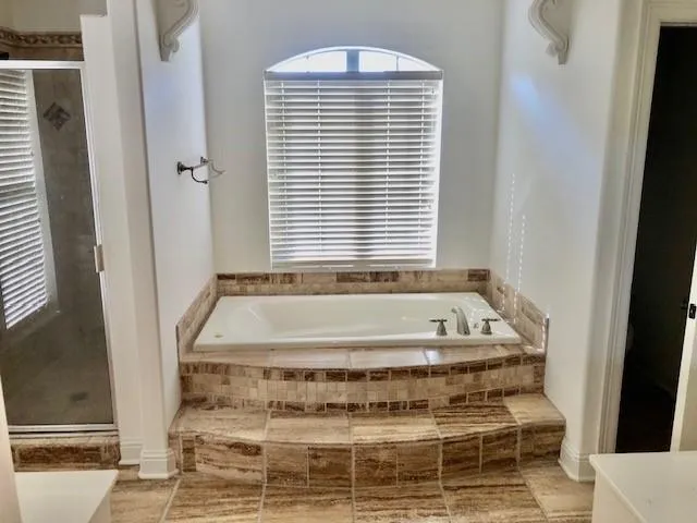 a bathroom with bathtub next to a window